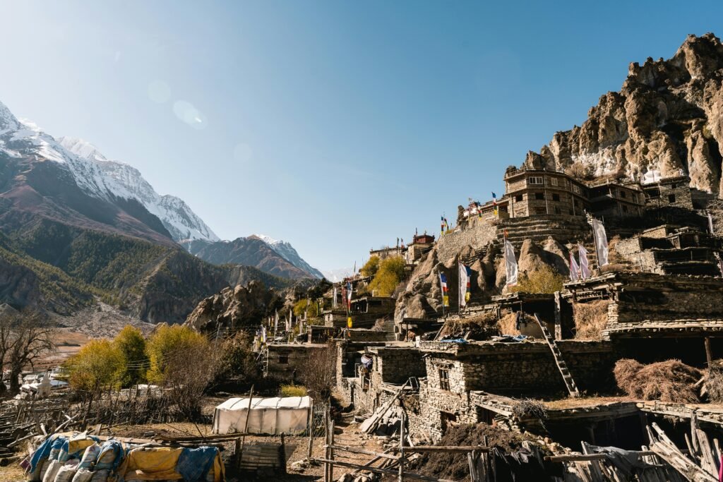 A scenic view of a traditional Nepalese village set against the majestic Himalayas.